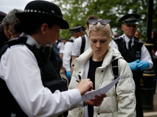 LONDON, ENGLAND - MAY 16: A police officer fines a protester as people demonstrate against