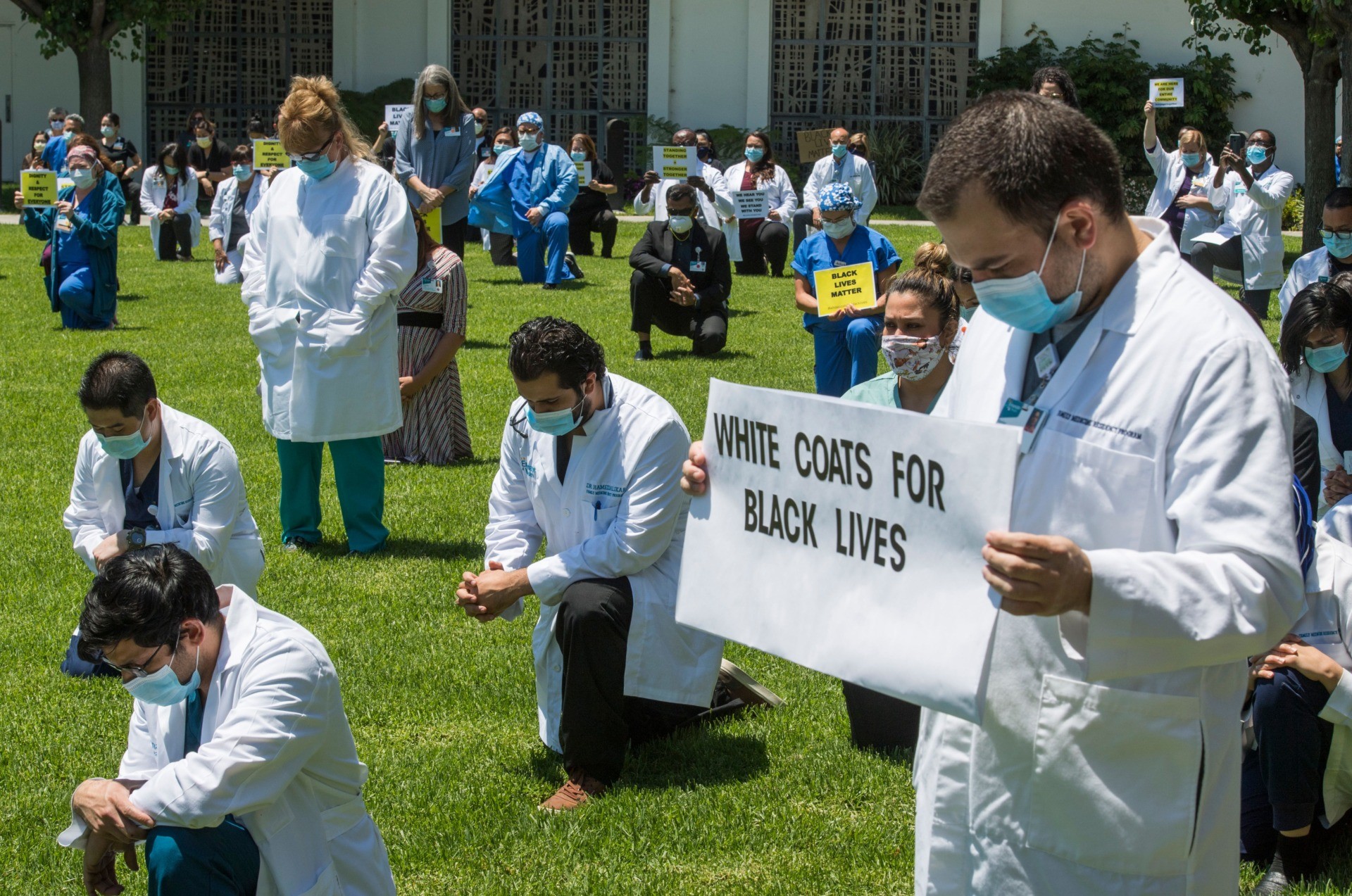 People kneel as doctors, nurses and other health care workers participate in a "White Coats for Black Lives" event in solidarity with George Floyd and other black Americans killed by police officers, at the Queen of the Valley Hospital in West Covina, California on June 11, 2020. - George Floyd's killing by a police officer touched off worldwide protests over racial and social injustice. (Photo by Mark RALSTON / AFP) (Photo by MARK RALSTON/AFP via Getty Images)