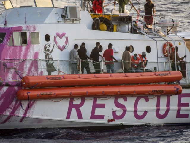 TOPSHOT - Migrants stand on the rescue ship funded by British street artist Banksy "L