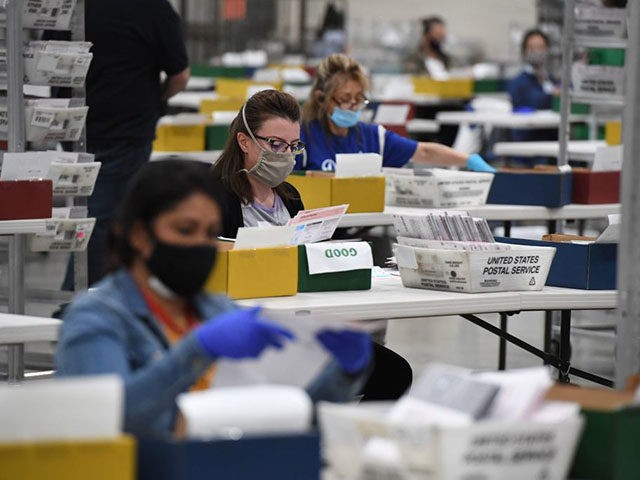 Election workers extract mail-in ballots from their envelopes and examine the ballot for irregularities at the Los Angeles County Registrar Recorders' mail-in ballot processing center at the Pomona Fairplex in Pomona, California, October 28, 2020. - Officials relocated mail-in ballot processing to the expansive location due to the need for …