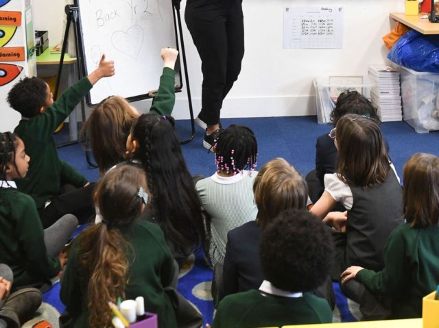 Teacher Ruby Muir talks to her Year 2 primary school students at Halley House School in east London, on March 8, 2021 as schools reopen following the easing of England's third coronavirus lockdown restrictions. - Millions of children returned to school in England on Monday for the first time in …