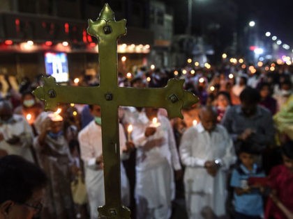 Christian devotees hold candles during a Easter vigil procession at Central Brooks Memori