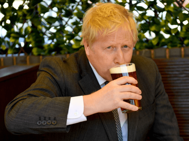 WOLVERHAMPTON, ENGLAND - APRIL 19: Prime Minister Boris Johnson sips a pint in the beer garden during a visit to The Mount pub and restaurant on April 19, 2021 in Wolverhampton, United Kingdom. The Prime Minister is on the local election campaign trail in West Midlands, (Photo by Jacob King …