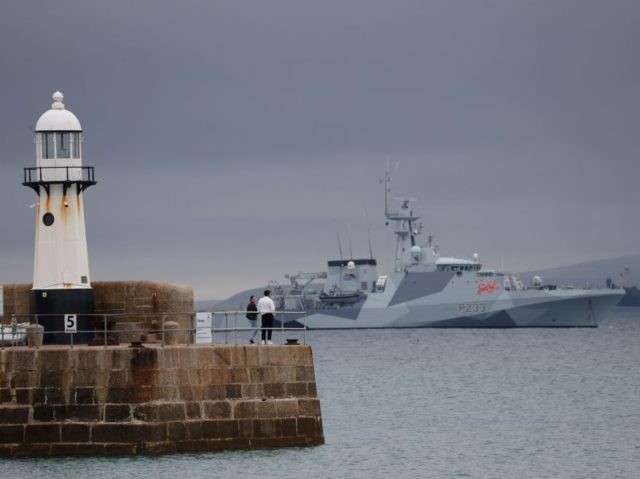 Visitors watch as the offshore patrol vessel HMS Tamar of the Royal Navy patrols off st Ives, Cornwall on June 9, 2021, ahead of the G7 summit. - G7 leaders from Canada, France, Germany, Italy, Japan, the UK and the United States meet this weekend for the first time in …