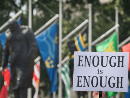 LONDON, ENGLAND - JULY 19: A protester holds a sign stating Enough is enough with the Churchill statue looking on as part of a freedom demonstration on July 19, 2021 in London, England. Anti-lockdown protests have been a feature of the Coronavirus Pandemic across the UK uniting the anarchist left …