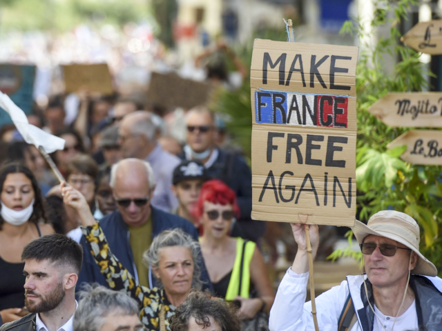 A demonstrator holds up a banner which reads as "Make France free again", during a national day of protest against the compulsory Covid-19 vaccination for certain workers and the mandatory use of the health pass called for by the French government in Nantes, western France on August 7, 2021. - …