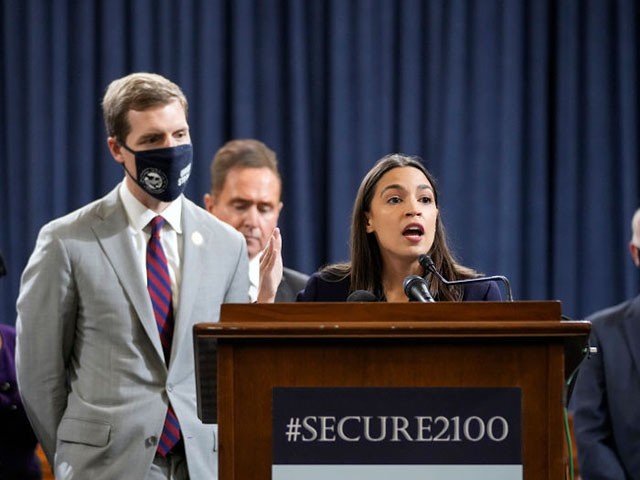 WASHINGTON, DC - OCTOBER 26: (L-R) House Ways and Means Social Security Subcommittee chairman Rep. John Larson (D-CT) and Rep. Conor Lamb (D-PA) look on as Rep. Alexandria Ocasio-Cortez (D-NY) speaks during a news conference to discuss legislation that would strengthen Social Security benefits, on Capitol Hill October 26, 2021 in Washington, DC. The lawmakers discussed their proposed bill, called the Social Security 2100 Act, which would include increased minimum benefits and add caregiver credits for people who have to leave the workforce to care for children or elderly family members. (Photo by Drew Angerer/Getty Images)