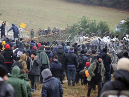 TOPSHOT - A picture taken on November 8, 2021 shows migrants at the Belarusian-Polish border in the Grodno region. - Poland on November 8 said hundreds of migrants in Belarus were descending on its border aiming to force their way into the EU member in what NATO slammed as a …