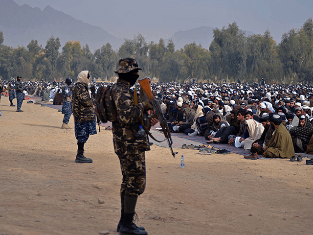 Taliban fighters stand guard as Afghans prepare to offer special prayers for rains at Eidg