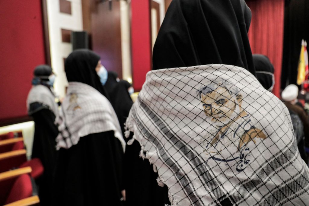 Women wear neckscarves showing an image of Qasem Soleimani, the slain top commander of the Iranian revolutionary guard corps (IRGC), during a memorial service marking the second anniversary of his death alongside Iraqi commander Abu Mahdi al-Muhandis in a US raid, at a hall in a school in the southern suburb of Lebanon's capital Beirut on January 3, 2022. (Photo by ANWAR AMRO / AFP) (Photo by ANWAR AMRO/AFP via Getty Images)