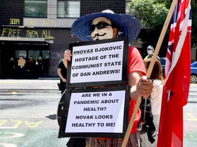 An anti-vax protester holds placards at a government detention centre where Serbia's tennis champion Novak Djokovic is reported to be staying in Melbourne on January 7, 2022, after Australia said it had cancelled the entry visa of Djokovic, opening the way to his detention and deportation in a dramatic reversal for the tennis world number one. (Photo by William WEST / AFP) (Photo by WILLIAM WEST/AFP via Getty Images)