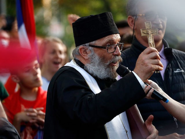 A Serbian orthodox priest gestures as supporters of Serbia's Novak Djokovic gather during a prayer outside a government detention centre where the tennis champion is reported to be staying in Melbourne on January 7, 2022, after Australia said it had cancelled the entry visa of Djokovic, opening the way to his detention and deportation in a dramatic reversal for the tennis world number one. (Photo by CON CHRONIS / AFP) (Photo by CON CHRONIS/AFP via Getty Images)