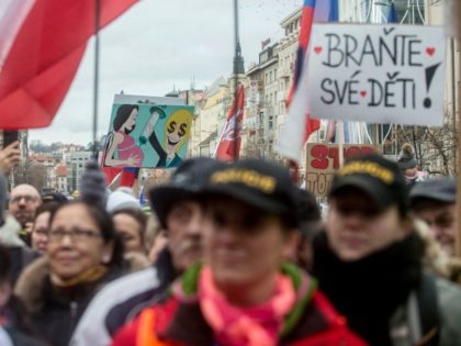 Demonstrators march with placards and the Czech national flag as they take part in a protest against compulsory vaccination against the coronavirus (Covid-19) in Prague on January 9, 2022, during the ongoing pandemic. - Following a deceleration at the end of last year, daily infection rates in Czech Republic have …