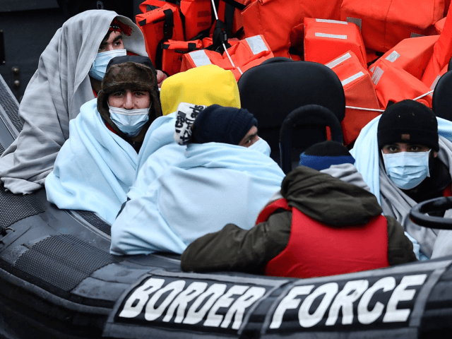 Migrants picked up at sea while attempting to cross the English Channel, are pictured on a UK Border Force patrol boat on arrival at the Marina in Dover, southeast England, on January 10, 2022. - Last year, record numbers of more than 28,000 migrants who paid thousands of pounds to …