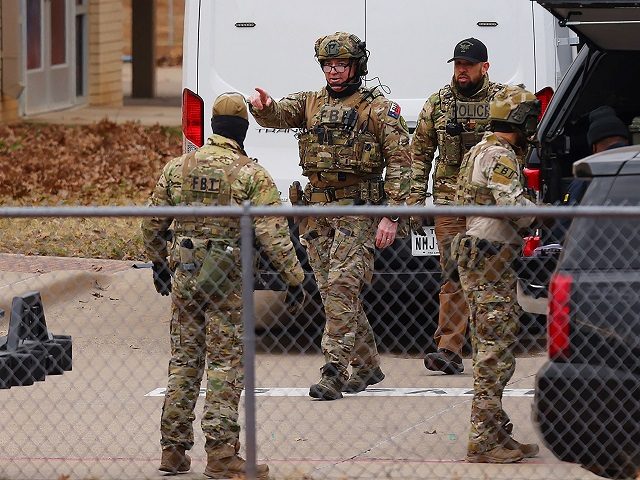 SWAT team members deploy near the Congregation Beth Israel Synagogue in Colleyville, Texas, some 25 miles (40 kilometers) west of Dallas, on January 15, 2022. - The SWAT police operation was underway at the synagogue where a man claiming to be the brother of a convicted terrorist has reportedly taken …
