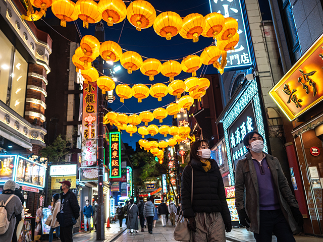 People walk underneath festive lanterns in the Chinatown shopping street in Yokohama on January 16, 2022, ahead of the Chinese Lunar New Year of Tiger. (Photo by Philip FONG / AFP) (Photo by PHILIP FONG/AFP via Getty Images)