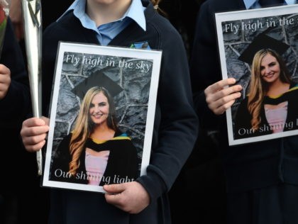 TULLAMORE, IRELAND - JANUARY 18: Pupils from Ashling Murphy's class hold photographs of her and red roses ahead of her funeral at St. Brigid’s Church, County Offaly on January 18, 2022 in Tullamore, Ireland. The murder of the beloved 23 year old school teacher has caused widespread anger and shock …