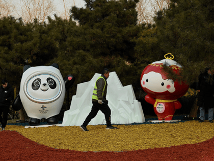 A worker walks in front of a display of Bing Dwen Dwen (L) and Shuey Rhon Rhon (R), mascots of the 2022 Beijing Winter Olympics and Paralympic Games respectively, in Beijing on January 18, 2022. (Photo by Noel Celis / AFP) (Photo by NOEL CELIS/AFP via Getty Images)