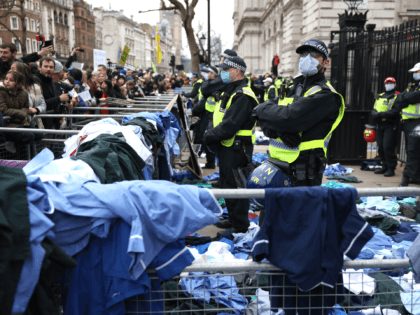 LONDON, ENGLAND - JANUARY 22: Activists from the World Wide Rally For Freedom and NHS100K protests throw NHS uniforms at police officers outside Downing Street on January 22, 2022 in London, England. Despite the government abandoning Plan B restrictions next week protesters are also demanding a stop to covid vaccines …