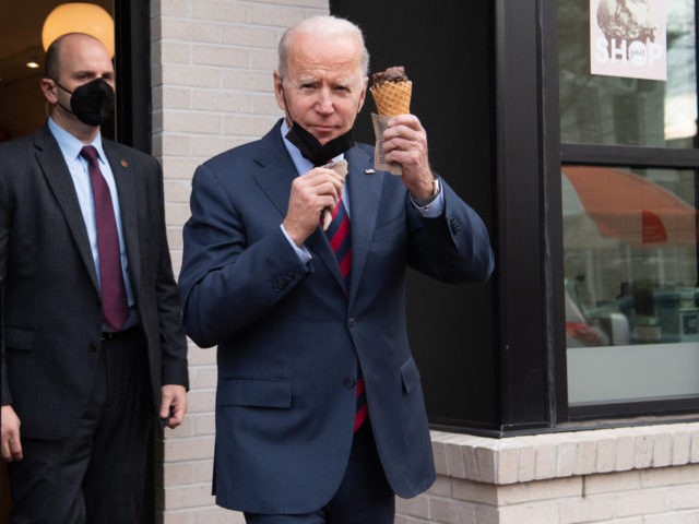 US President Joe Biden carries an ice cream cone as he leaves Jeni's Ice Cream in Was