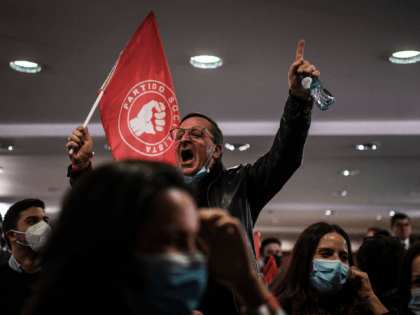 Supporters cheer after the announcement of the first exit polls at the Socialist Party cam