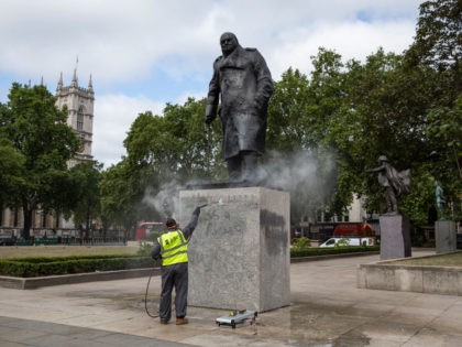 LONDON, ENGLAND - JUNE 08: A worker cleans the Churchill statue in Parliament Square that