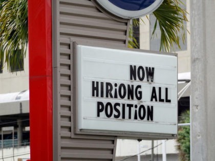 MIAMI, FLORIDA - OCTOBER 08: A 'now hiring' sign outside of a business on Octobe