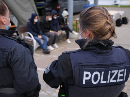 FRANKFURT (ODER), GERMANY - OCTOBER 12: German federal police officers stand over four men who said they are from Afghanistan who had crossed illegally into Germany across the border from Poland on October 12, 2021 in Frankfurt (Oder), Germany. Police are reporting a dramatic increase in the numbers of illegal …