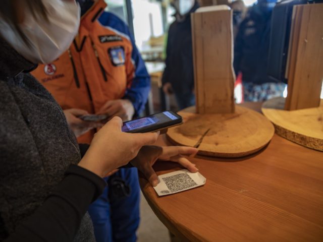 BOLZANO, ITALY - DECEMBER 12: People have their Green Pass checked before entering a restaurant next to the ski slopes on December 12, 2021 in Obereggen, Italy. Ski facilities remained inactive for two years during the Covid-19 pandemic, re-opening in recent weeks with the hope of boosting tourism, yet with …