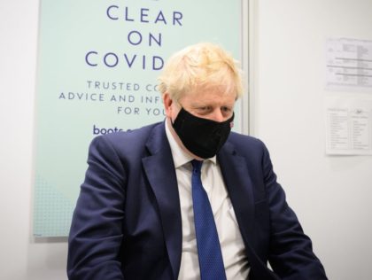UXBRIDGE, ENGLAND - JANUARY 10: Britain's Prime Minister Boris Johnson prepares to watch a man receive his Covid-19 booster jab as he makes a constituency visit to a Boots pharmacy on January 10, 2022 in Uxbridge, England. (Photo by Leon Neal/Getty Images)