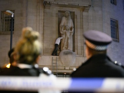 LONDON, ENGLAND - JANUARY 12: Police officers cordon off the area as a protester is seen attempting to damage a statue by sculptor Eric Gill on BBC Broadcasting House on January 12, 2022 in London, England. The statue, Prospero And Ariel, was sculpted in 1932 by Eric Gill, who revealed …