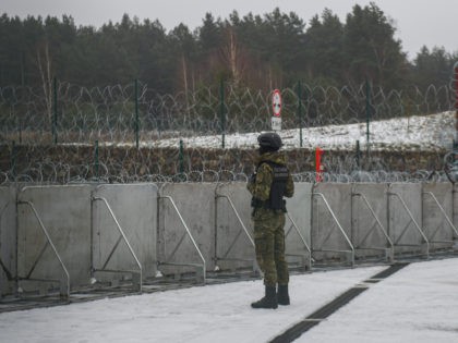KUZNICA, POLAND - JANUARY 13: A border guard officer stands guard next to a blockade at the Kuznica-Bruzgi checkpoint on the Polish-Belarusian border during a media trip to the militarized area on January 13, 2022 in Kuznica, Poland. The NGO Medecins Sans Frontieres (MSF) pulled out from the border region …