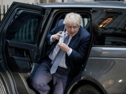 LONDON, ENGLAND - JANUARY 25: Prime Minister Boris Johnson removes his face mask as he ret