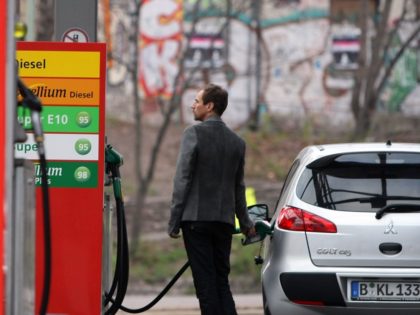 BERLIN, GERMANY - APRIL 03: A man watches a fuel pump as he fills his car at a gas pump at