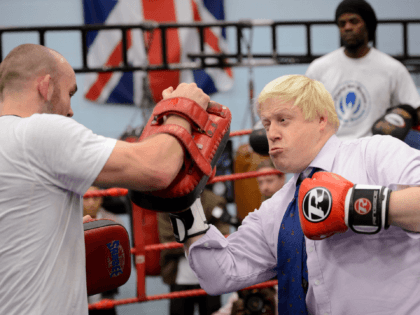 Mayor of London Boris Johnson boxes with a trainer during his visit to Fight for Peace Academy in North Woolwich, London, on October 28, 2014. Fight for Peace uses boxing and martial arts combined with education and personal development to realise the potential of young people in the borough at …
