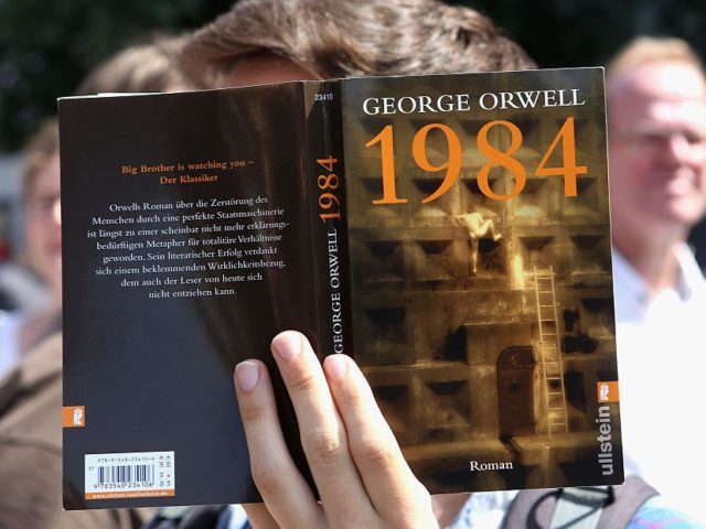 BERLIN, GERMANY - AUGUST 01: A protester holds a German translation of George Orwell's book '1984' as he demonstrates for journalists' rights on August 1, 2015 in Berlin, Germany. After two German journalists, Andre Meister and Markus Beckedahl, reported that the German government planned to increase online surveillance, an investigation …