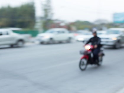 car and motorcycle driving on road with traffic jam in the city, abstract blurred backgrou