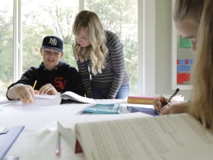 FILE - In this Oct. 9, 2019, photo, Donya Grant, center, works on a homeschool lesson with her son Kemper, 14, as her daughter Rowyn, 11, works at right, at their home in Monroe, Wash. The rate of households homeschooling their children doubled from the start of the pandemic last …