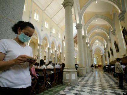 A Catholic woman reads the bible in Hong Kong's Roman Catholic Cathedral in Central district wearing a mask to protect against a killer pneumonia on Good Friday, 18 April 2003. The disease known as Severe Acute Respiratory Sydrome (SARS) has now killed 66 people in the territory since it erupted …