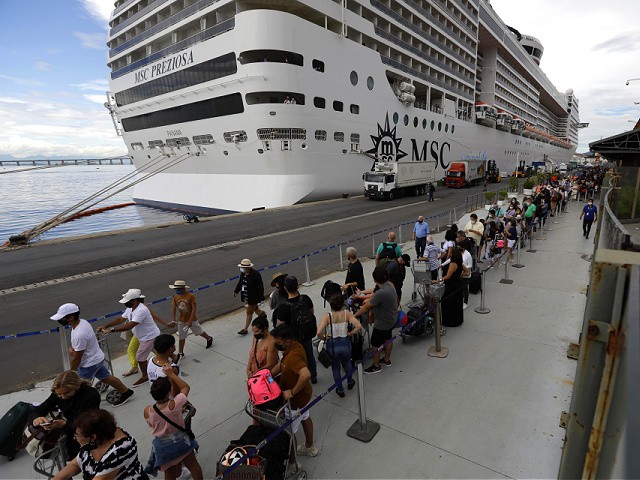 Passengers disembark from the cruise ship 'MSC Preziosa'', in the Port Area of Rio de Janeiro, Brazil, Sunday, Jan. 2, 2022, after Brazil's Sanitary Agency has confirmed more cases of COVID-19 on board. Rio's Health Secretariat said that those living in the city or nearby regions will be quarantined in their homes. Those who live outside the state will be isolated in hotels. (AP Photo/Bruna Prado)