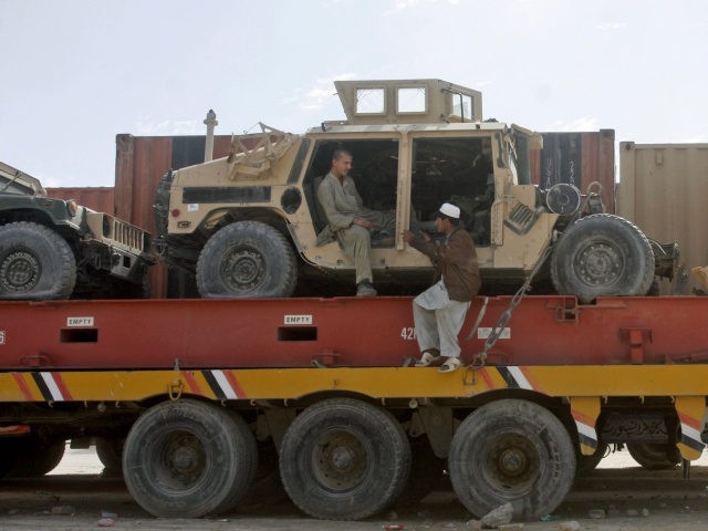 Pakistani driver assistants chat while sitting on a truck carrying NATO Humvees at a terminal on the Pakistani-Afghan border in Chaman, Pakistan, Monday, Feb. 11, 2013. The U.S. says it has started using the land route through Pakistan to pull American military equipment out of Afghanistan. (AP Photo/Matiullah Achakzai)
