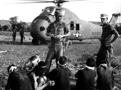 Viet Cong prisoners wait in front of a U.S. Marine Corps Sikorsky UH-34D Seahorse helicopter of Marine medium transport squadron HMM-161, during "Operation Starlight" south of Chu Lai, South Vietnam, on 1 August 1965.