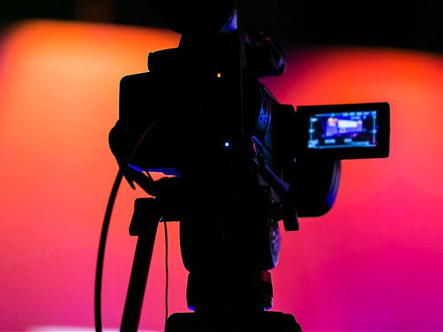 Silhouette of a TV Camera filming a live broadcast - stock photo