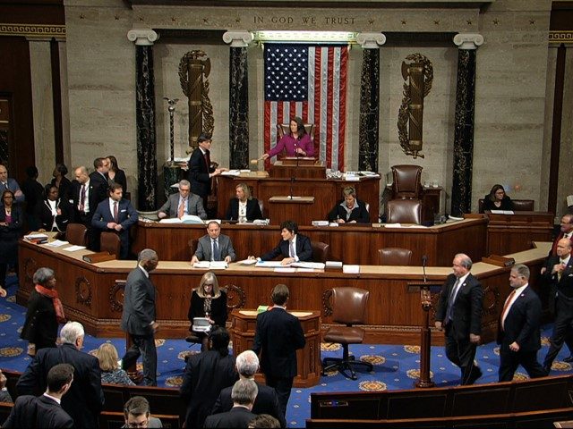 Members walk on the floor as voting begins in the House of Representatives in the first article of impeachment against President Donald Trump at the Capitol in Washington, Wednesday, Dec. 18, 2019.