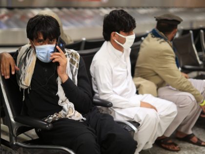 DULLES, VIRGINIA - AUGUST 27: Refugees wait for transportation at Dulles International Airport after being evacuated from Kabul following the Taliban takeover of Afghanistan August 27, 2021 in Dulles, Virginia. Refugees continued to arrive in the United States one day after twin suicide bombings at the gates of the airport …
