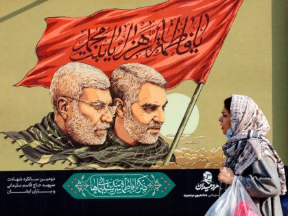 An Iranian woman walks past a large poster of slain top Iranian general Qasem Soleimani (R) and senior Hashed commander Abu Mahdi al-Muhandis ahead of the second anniversary of their death, in the capital Tehran, on December 31, 2021. - Soleimani and senior Hashed commander Abu Mahdi al-Muhandis were killed …