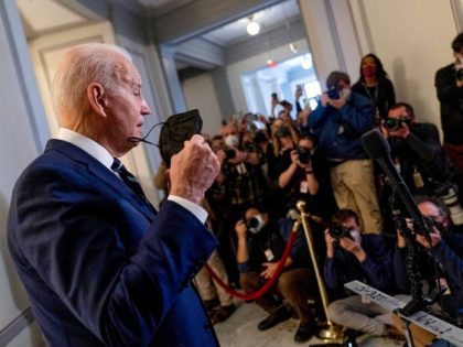 President Joe Biden takes off his mask to speak to members of the media as he leaves a meeting with the Senate Democratic Caucus to discuss voting rights and election integrity on Capitol Hill in Washington, Thursday, Jan. 13, 2022. (AP Photo/Andrew Harnik)