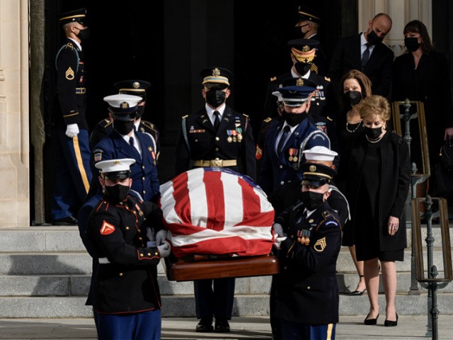 WASHINGTON, DC - DECEMBER 10: Elizabeth Dole and Robin Dole walk alongside a military honor guard as they carry the casket of the late former Senator Robert Dole (R-KS) at the conclusion of his funeral service at Washington National Cathedral on December 10, 2021 in Washington, DC. Dole, a veteran who was severely injured in World War II, was a Republican Senator from Kansas from 1969 to 1996. He ran for president three times and became the Republican nominee for president in 1996. (Photo by Drew Angerer/Getty Images)