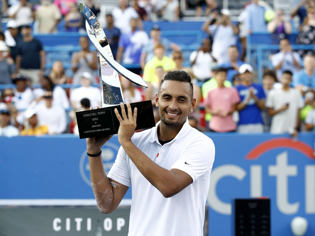 Nick Kyrgios, of Australia, poses for photos with a trophy after defeating Daniil Medvedev