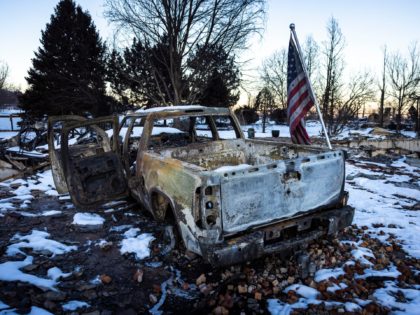 LOUISVILLE, CO - JANUARY 02: An American flag is shown affixed to a burned truck in a neighborhood decimated by the Marshall Fire on January 2, 2022 in Louisville, Colorado. Officials reported that 991 homes were destroyed, making it the most destructive wildfire in Colorado history. (Photo by Michael Ciaglo/Getty …